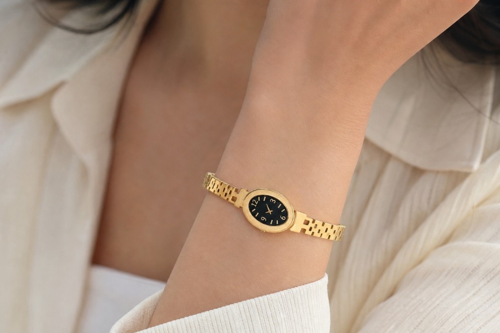 Model wearing an elegant gold oval watch
